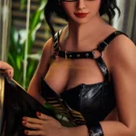 Avelina Sex Doll 168 cm en robe noire et lunettes, posant élégamment avec des détails réalistes.
