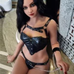 Avelina Sex Doll 168 cm en cuir noir, assise près d'un miroir, cheveux longs et noirs.