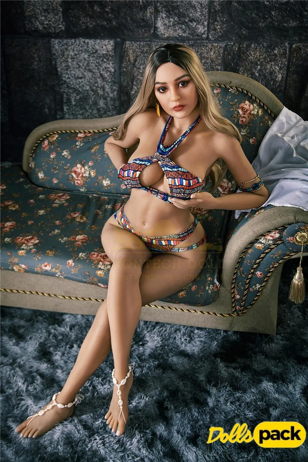 Bella Sex Doll 159 cm IronTech Doll TPE assise sur canapé, en bikini coloré, jambes croisées.
