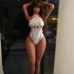 Bellea Sex Doll 153 cm IronTech Doll TPE debout en body blanc moulant devant une fenêtre.