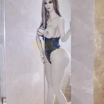 Charmella Sex Doll 170 cm IronTech dans une douche, pose debout, regard vers l'avant.