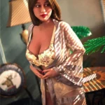 Eliya Sex Doll 163 cm en robe légère, posée debout près d'une table décorative.