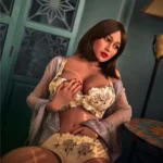 Eliya Sex Doll 163 cm IronTech en lingerie jaune, posée sensuellement sur un fauteuil.