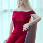 Elodie Sex Doll 170 cm en robe rouge, assise sur une chaise, cheveux blonds lâchés.