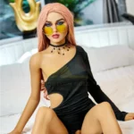 Elodora Sex Doll 165 cm IronTech Doll TPE assise en robe noire asymétrique, lunettes jaunes.