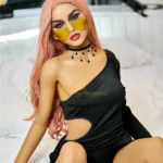 Elodora Sex Doll 165 cm IronTech Doll TPE assise, robe noire asymétrique, lunettes jaunes.