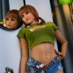Eloiah Sex Doll 159 cm IronTech, debout en miroir, t-shirt vert, short jean étoilé.