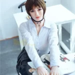 Elsalune Sex Doll 159 cm IronTech, assise à table, chemise blanche, lisant un magazine.