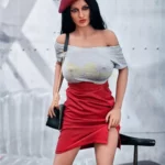 Enora Sex Doll 163 cm avec jupe rouge et béret, posant debout près d'une chaise.
