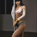 Florine Sex Doll 168 cm IronTech en pose debout, tenue décontractée près d'une barre de pole dance.