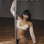 Florine Sex Doll 168 cm posée sensuellement près d'une barre, tenue légère, ambiance intérieure.