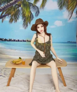 Isabelle Sex Doll 157cm IronTech Doll TPE assise sur un banc, plage en arrière-plan, chapeau de paille.