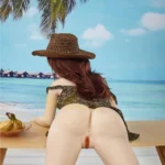 Isabelle Sex Doll 157cm en bikini, chapeau de paille, posée sur une table face à la mer.