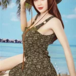 Isabelle Sex Doll 157cm IronTech Doll TPE en robe fleurie, assise avec chapeau de paille.
