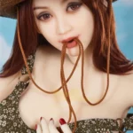 Isabelle Sex Doll 157cm IronTech, chapeau en paille, robe fleurie, fond bleu.