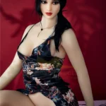 Lalori Sex Doll 168 cm IronTech Doll TPE en robe florale, assise sur fond rouge.