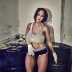 Léoline Sex Doll 158 cm IronTech en tenue sportive, posant près de barils industriels.
