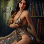 Lidora Sex Doll 163 cm IronTech en robe dorée, posant assise, ambiance bibliothèque.