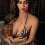 Lidora Sex Doll 163 cm IronTech Doll TPE en robe dorée, posée devant des livres.