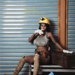 Lilizelle Sex Doll 163 cm IronTech en tenue de chantier, assise avec casque et gants.