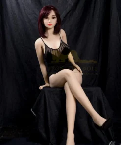 Lillyanne Sex Doll 157cm IronTech assise, robe noire, cheveux courts rouges, fond noir.