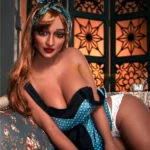 Lilona Sex Doll 161 cm IronTech Doll TPE posée sur un canapé, robe à pois bleus.