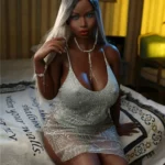 Liloué Sex Doll 158 cm IronTech en robe argentée assise sur un lit, ambiance élégante.