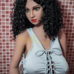 Lilybelle Sex Doll 160 cm IronTech TPE en robe blanche, cheveux bouclés, fond carrelé.