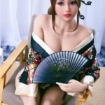 Liya Sex Doll 159 cm IronTech en kimono floral, assise avec éventail, cheveux attachés.