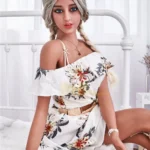 Lolitine Real Doll 169 cm IronTech Doll TPE assise en robe florale, cheveux tressés.