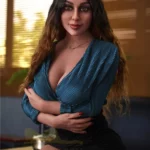 Lorabelle Sex Doll 161 cm IronTech en robe bleue, assise, bras croisés, cheveux longs ondulés.