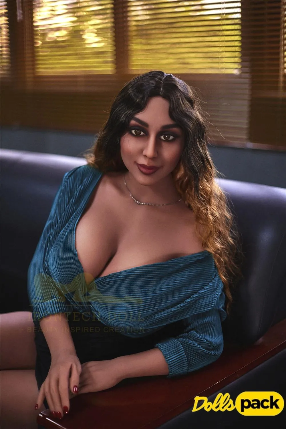 Lorabelle Sex Doll 161 cm IronTech, assise sur un canapé, robe bleue, cheveux ondulés.