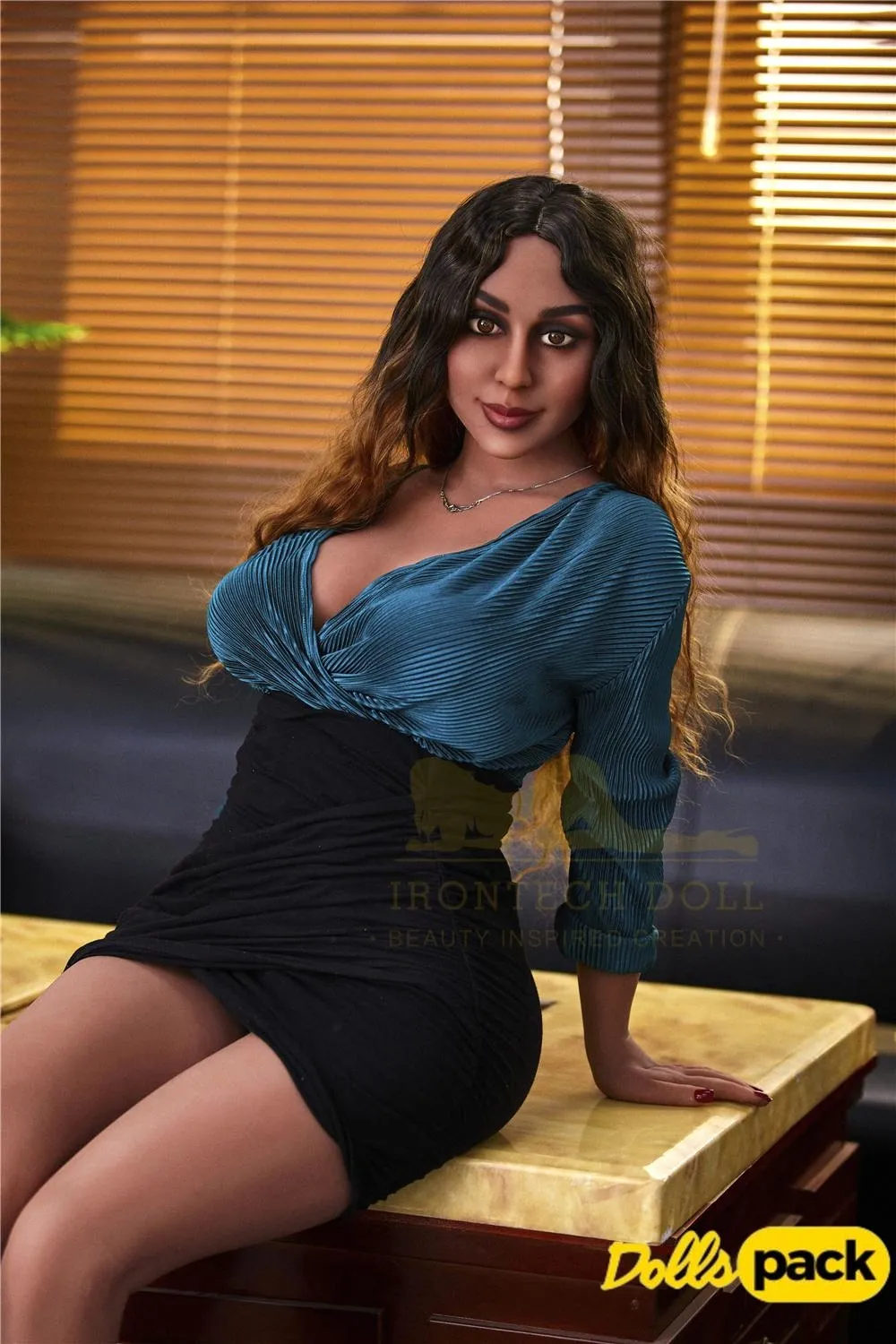 Lorabelle Sex Doll 161 cm assise sur table, robe bleue et noire, cheveux ondulés.