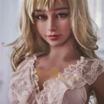Lovia Sex Doll 155 cm IronTech Doll TPE en robe rose, cheveux blonds bouclés, expression réaliste.