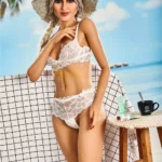 Lullia Valentina Sex Doll 165 cm en lingerie blanche, chapeau de paille, fond plage exotique.
