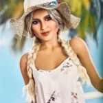 Lullia Valentina Sex Doll 165 cm en robe fleurie et chapeau, fond tropical.