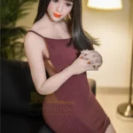 Luluca Sex Doll 161 cm IronTech en robe bordeaux, assise sur canapé, éclairage doux.