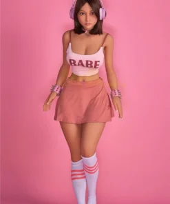 Lumabelle Sex Doll 153 cm IronTech en jupe rose, débardeur "Babe", écouteurs et chaussettes hautes.