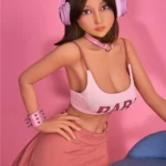 Lumabelle Sex Doll 153 cm IronTech Doll TPE en pose dynamique, tenue rose et casque audio.