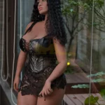 Luméa Sex Doll 158 cm IronTech posée debout, en lingerie noire, cheveux bouclés, intérieur moderne.