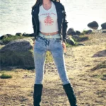 Lumelia Sex Doll 165 cm IronTech en jeans et veste cuir, pose debout près d'un lac.