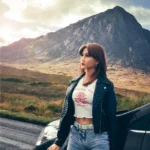 Lumelia Sex Doll 165 cm IronTech Doll TPE posée contre une voiture, montagne en arrière-plan.