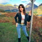 Lumelia Sex Doll 165 cm IronTech Doll TPE en veste noire, jeans, pose extérieure.