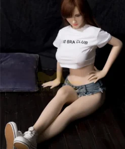 Lumiera Sex Doll 157cm IronTech en short en jean, t-shirt blanc, assise sur le sol.