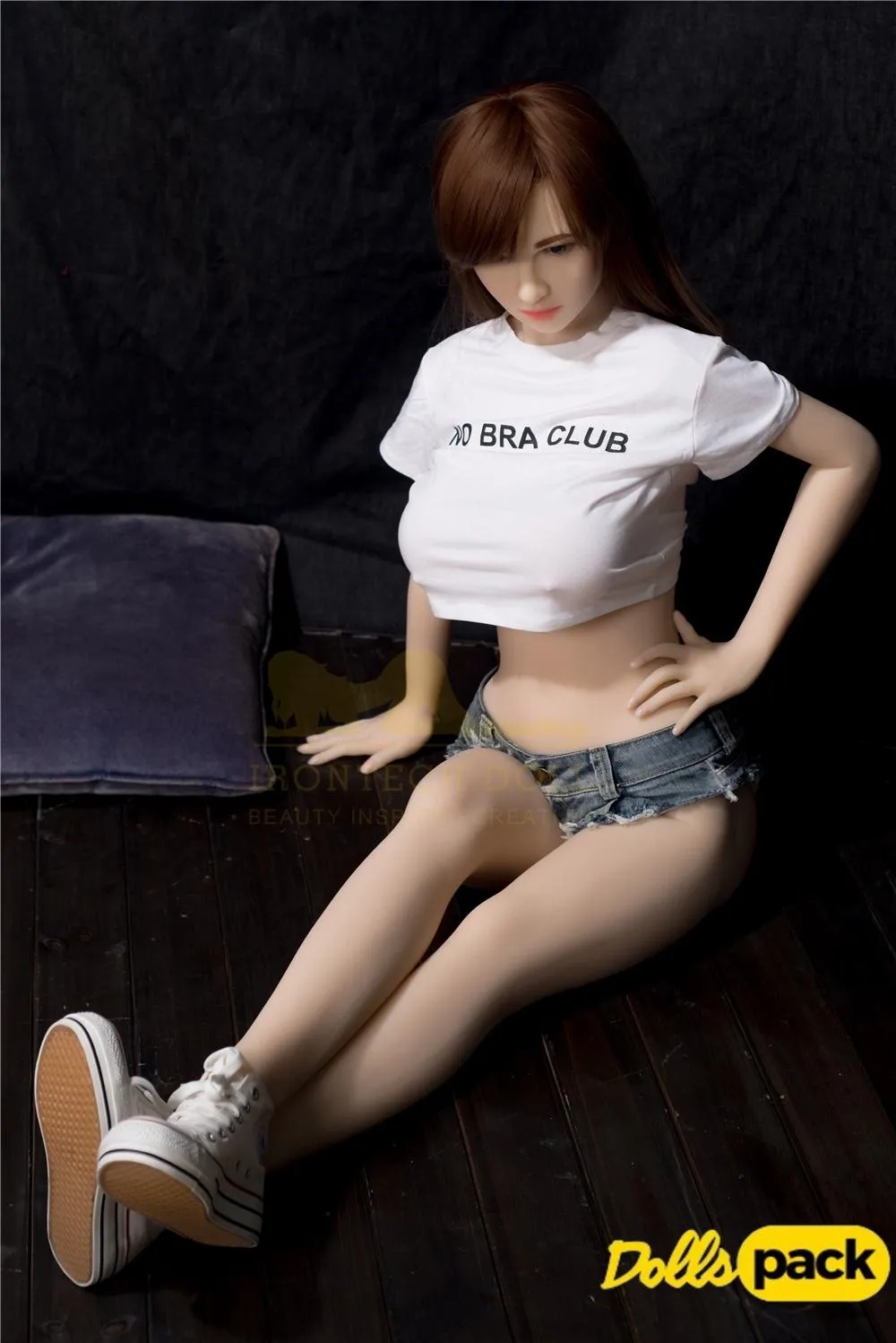 Lumiera Sex Doll 157cm IronTech en short en jean, t-shirt blanc, assise sur le sol.