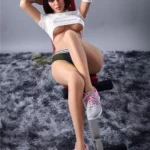 Lumière Sex Doll 159 cm IronTech Doll TPE assise, jambes croisées, tenue sportive.