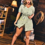 Lunala Sex Doll 156 cm IronTech Doll TPE en robe à carreaux verts, pose debout dans une pièce en bois.