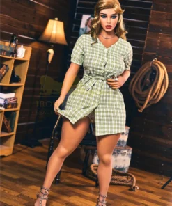 Lunala Sex Doll 156 cm IronTech Doll TPE en robe à carreaux verts, pose debout dans une pièce en bois.
