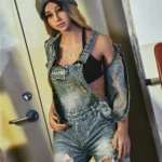 Lunia Sex Doll 163 cm IronTech en salopette denim et bonnet gris, pose décontractée.