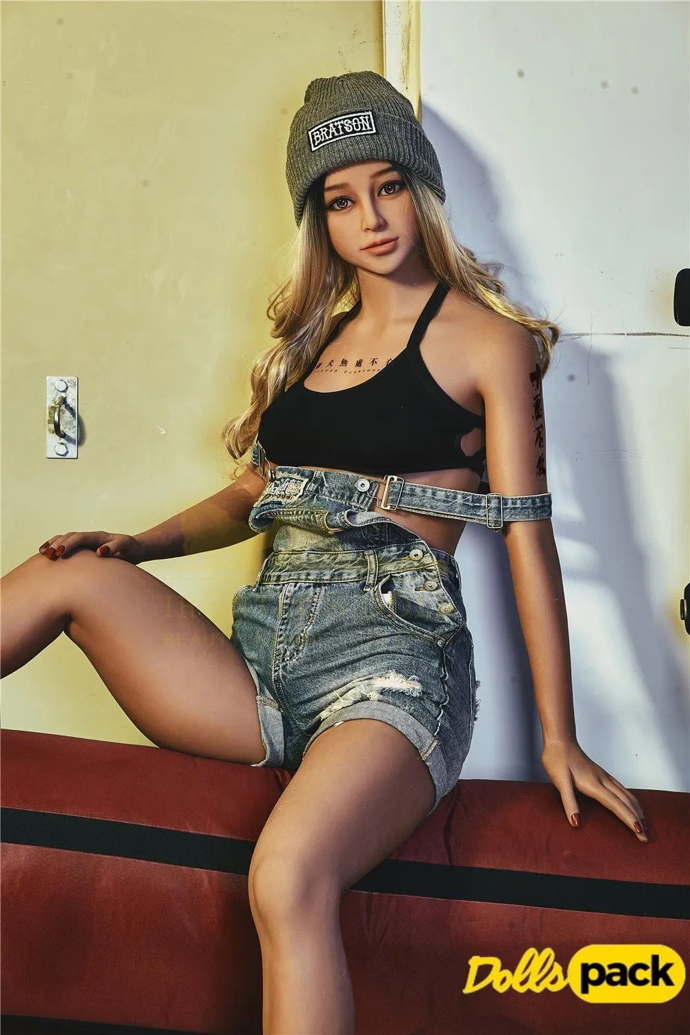 Lunia Sex Doll 163 cm IronTech posée assise, bonnet gris, top noir, short en jean.